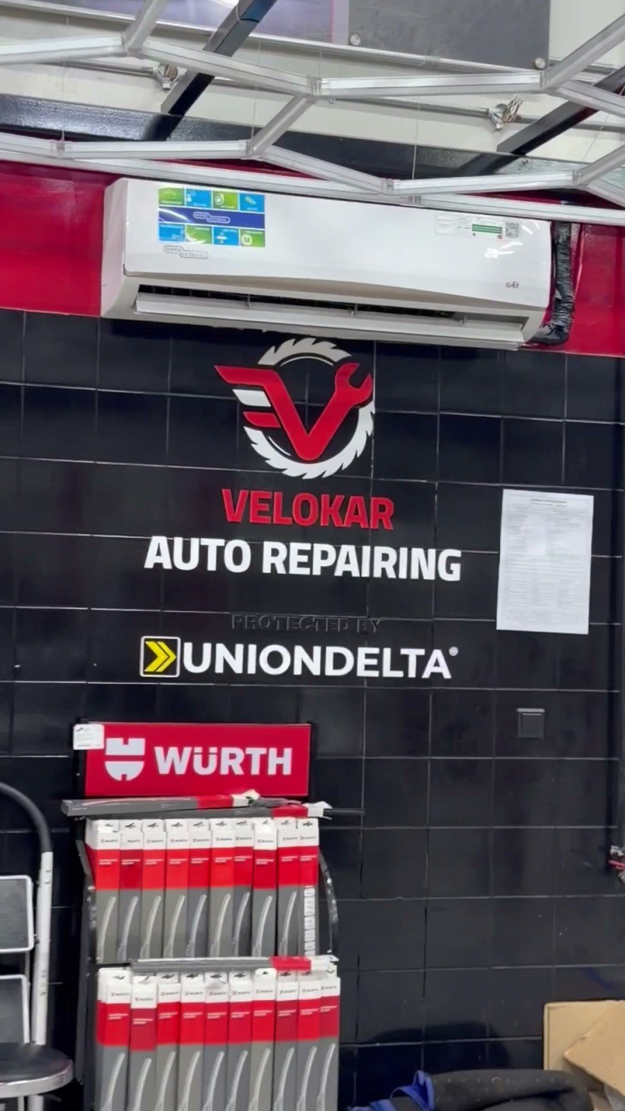 Velokar Auto Repairing sign on the workshop wall in Al Quoz Industrial 3, Dubai, with the Würth parts stand below