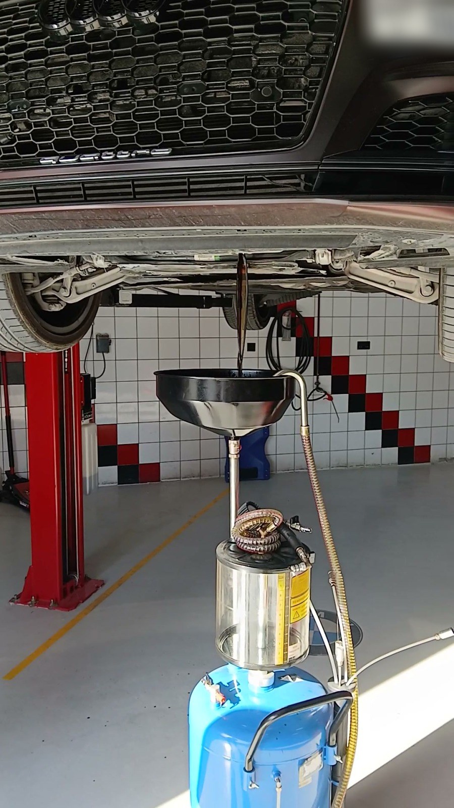 Audi raised on a lift with a waste-oil drain under the engine at Velokar, Al Quoz