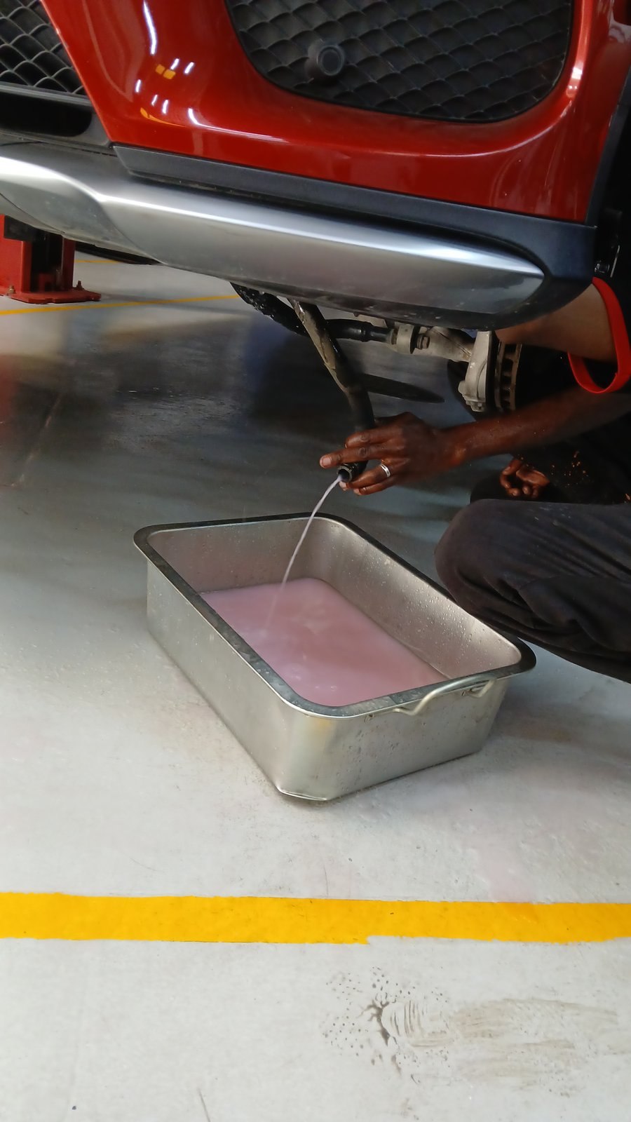 Flushing the AC evaporator drain on an SUV at Velokar in Al Quoz