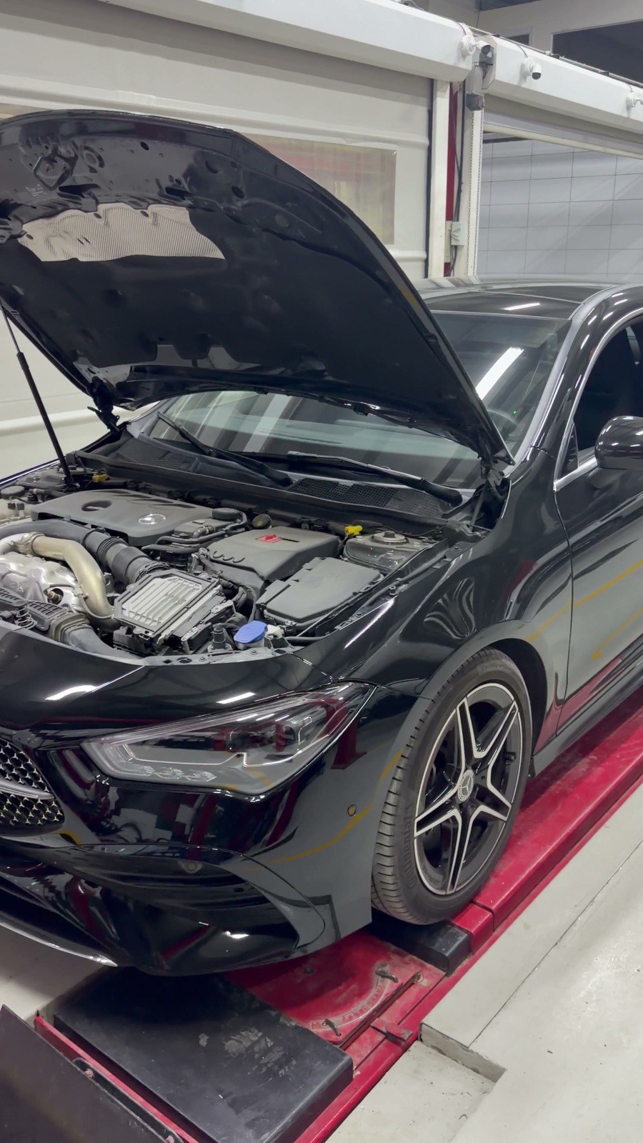 مرسيدس CLA سوداء بغطاء محرّك مفتوح على رافعة ضبط الزوايا في فيلوكار لإصلاح السيارات، القوز الصناعية 3، دبي