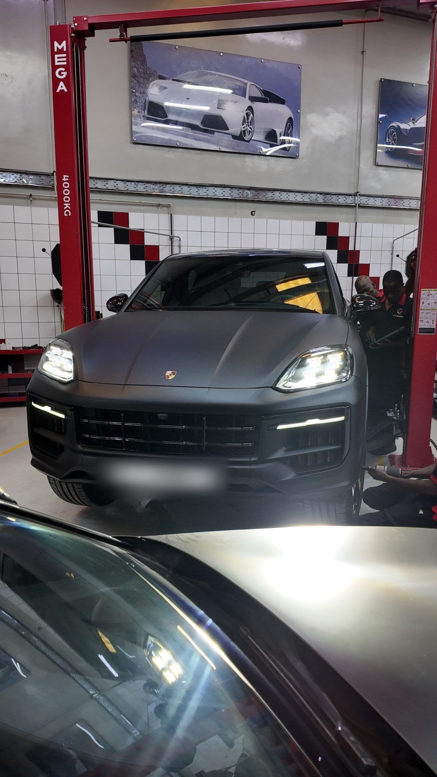 Matte Porsche Cayenne driving into the service bay at Velokar in Al Quoz