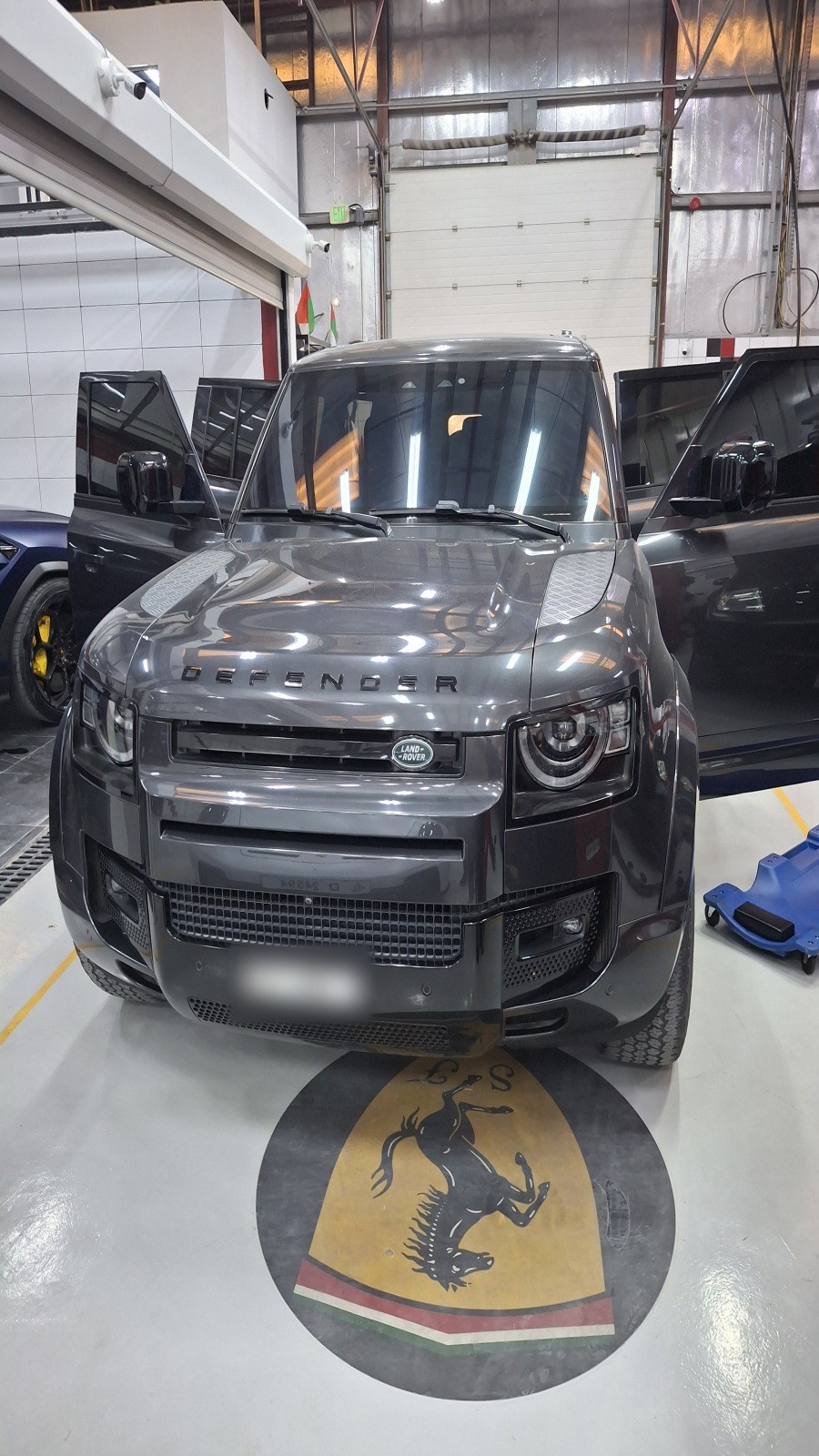 Land Rover Defender on the workshop floor at Velokar in Al Quoz, doors open for the inspection