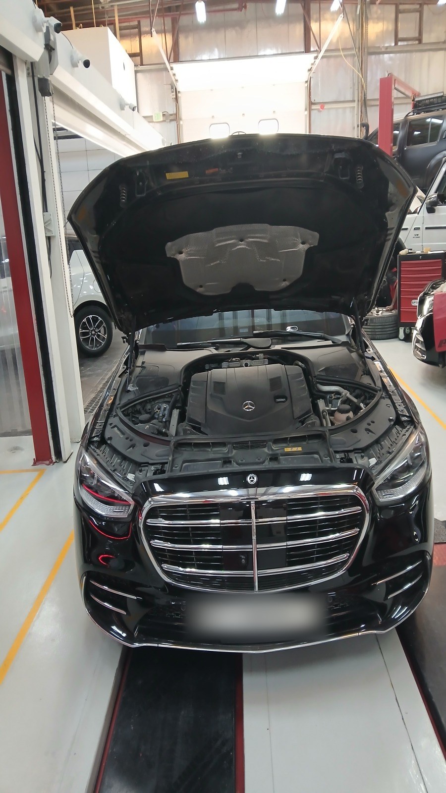 مرسيدس S-Class سوداء على الرافعة في فيلوكار بغطاء محرّك مفتوح وغطاء المحرّك ظاهر