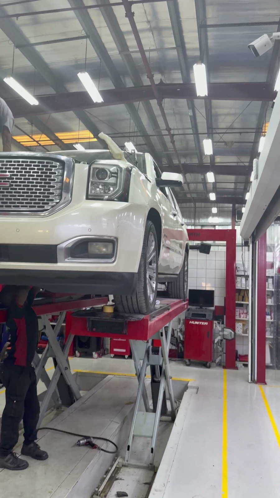 White SUV raised on the four-post alignment lift in the Velokar workshop, Al Quoz Industrial 3