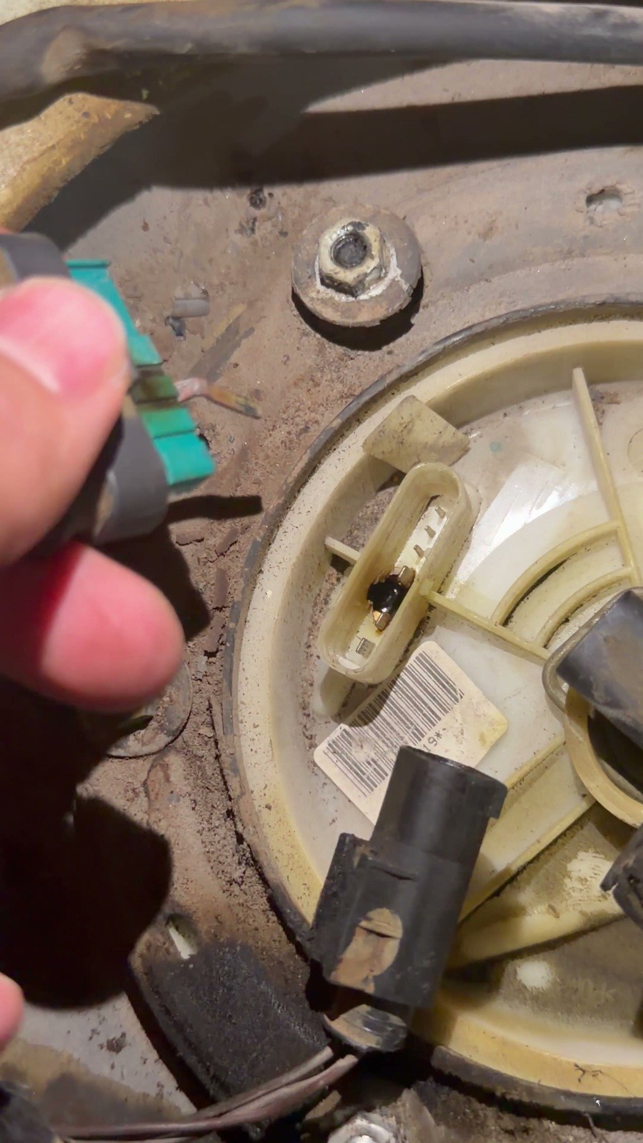 A technician holding a fuel pump connector during a repair at the Velokar workshop