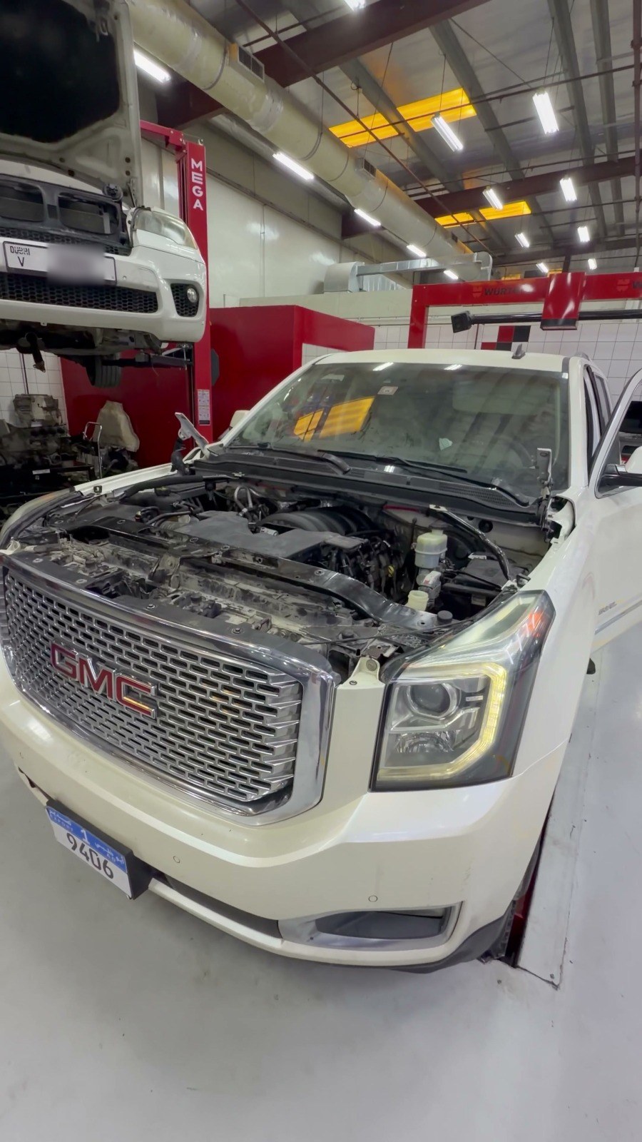 White GMC Yukon with the bonnet open inside the Velokar workshop in Al Quoz, Dubai