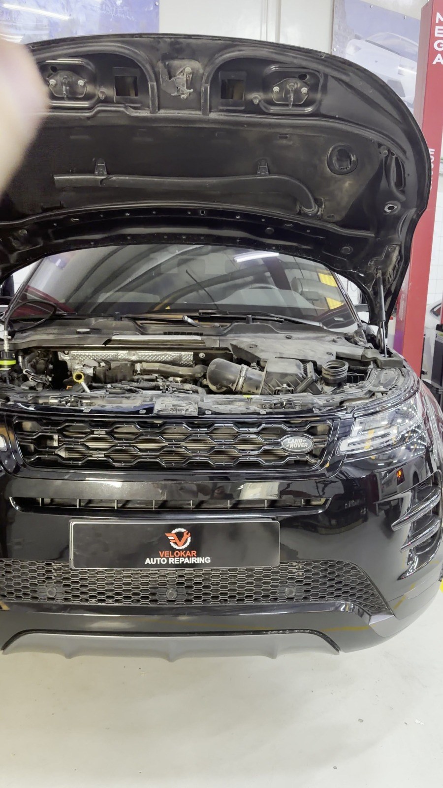 Black Range Rover with the bonnet open in a Velokar workshop bay, Dubai