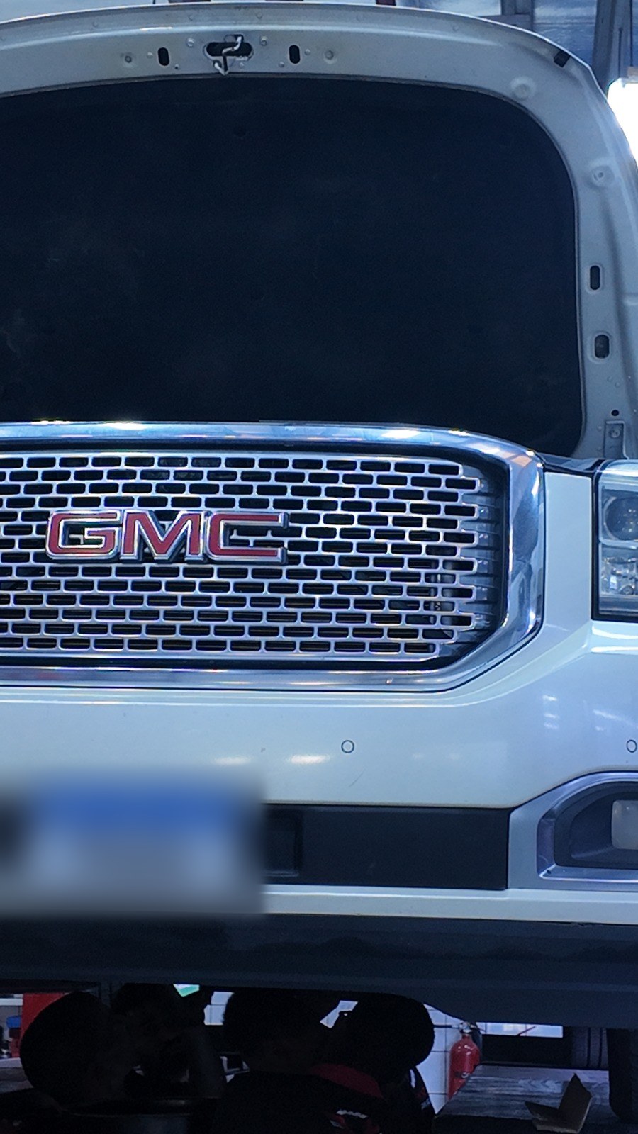 White GMC Yukon on the lift with the bonnet open at Velokar in Al Quoz